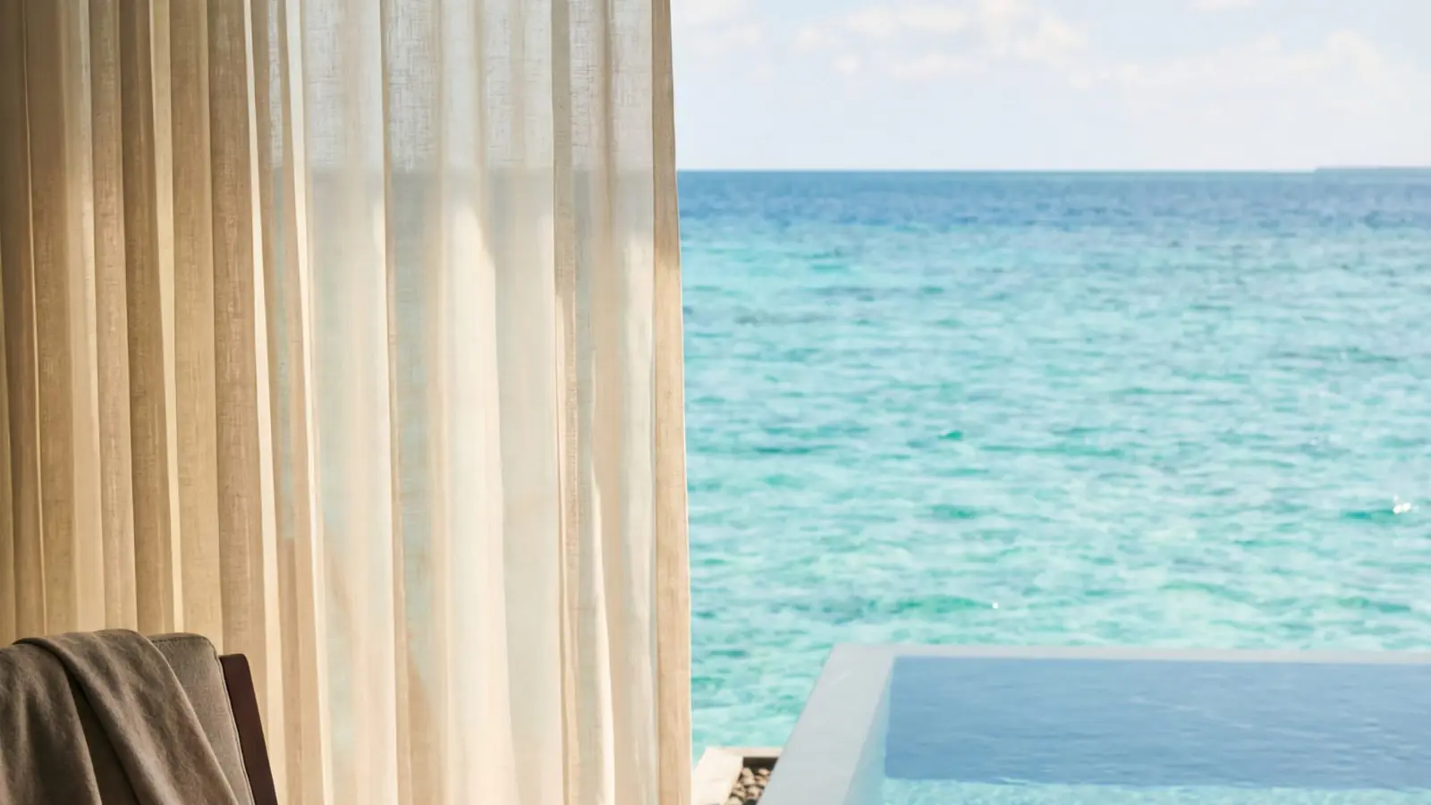 An overwater villa above a turquoise lagoon